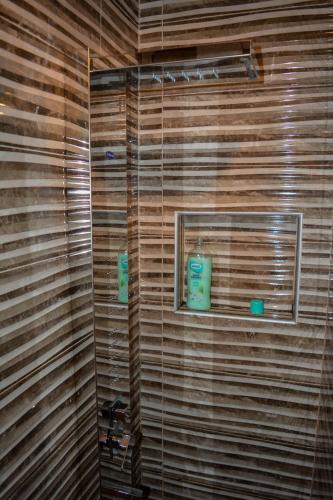 a bathroom with a wooden wall with two candles in it at Villa Tasnim in Dobrenica