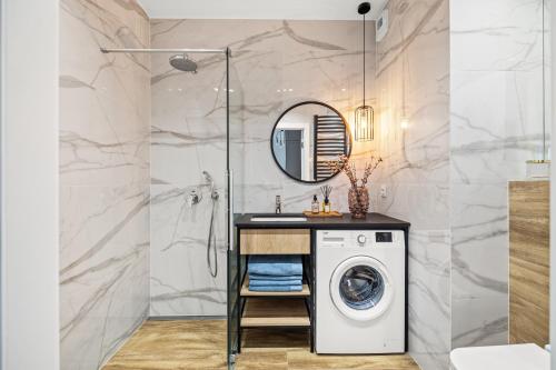 a bathroom with a washing machine and a mirror at Marina Primore - Hampton Apartments in Gdańsk