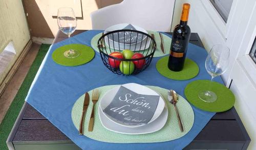 a table with a bottle of wine and a basket of fruit at Ferienwohnung 90 m2 in Sulzbach 2 Minuten Fußweg zum Krankenhaus in Sulzbach