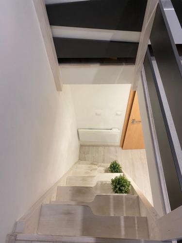 una escalera en una casa con paredes blancas y suelo de madera en Downtown Mini Apartment, en Budapest