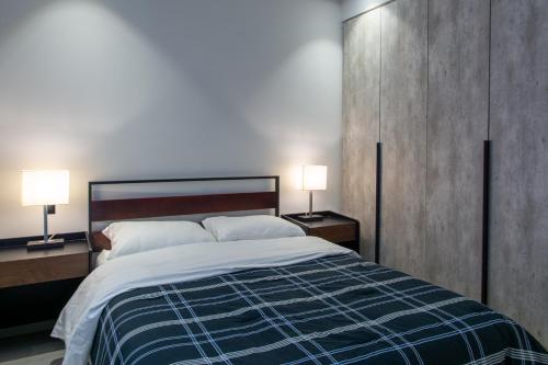 a bedroom with a large bed with two lamps at Mexication Penthouse: Urban Retreat Col. American in Guadalajara