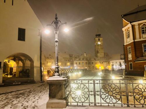een straatlicht op een hek in een stad 's nachts bij Casa Young&Jung in Sibiu