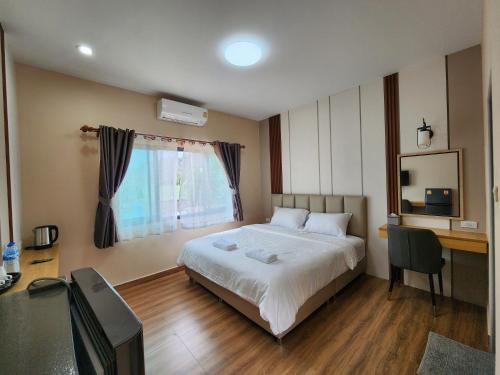 um quarto com uma cama, uma secretária e uma janela em LeMae Residence เลอเม เรสซิเดนซ์ อำเภอเขาย้อย เพชรบุรี em Ban Huai Krathaek