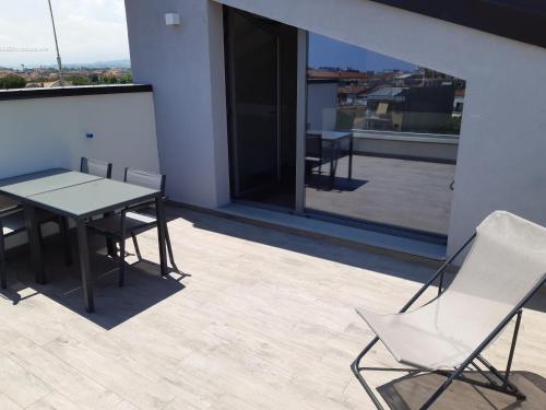 un patio con tavolo e sedie sul balcone. di LE DIMORE DI VIA VENEZIA a Civitanova Marche
