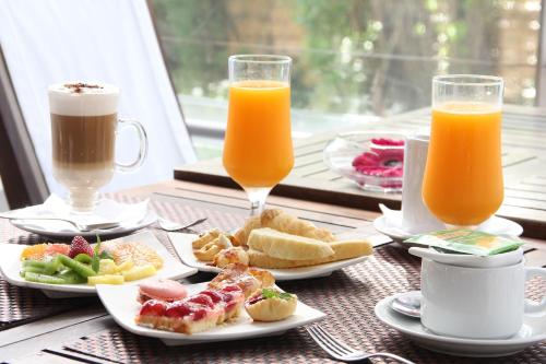 a table with plates of food and two glasses of orange juice at AWA Boutique + Design Hotel in Punta del Este