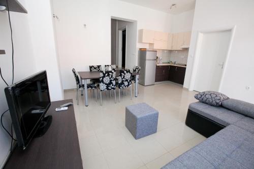 a living room with a couch and a table and a kitchen at Apartment Stipan in Bibinje