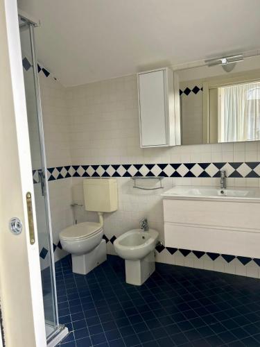 a bathroom with two toilets and a sink and a tub at Appartamento Borgomarina in Cervia