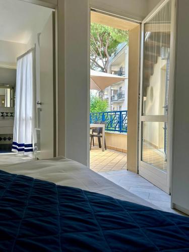 a bedroom with a door open to a patio at Appartamento Borgomarina in Cervia