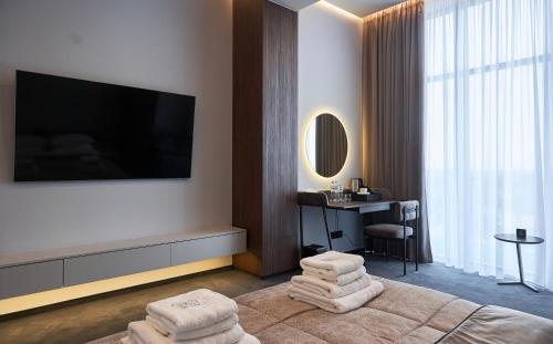 a hotel room with a television and towels at WHITE HILLS HOTEL spa&sport in Uzhhorod