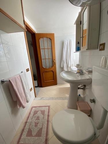 bagno bianco con servizi igienici e lavandino di La Casa dei Sogni a Procida