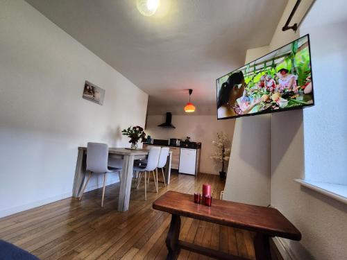 sala de estar con TV de pantalla plana en la pared en Gite Myrtille 2 à 6 personnes dans Residence des Buis avec Spa en Ventron