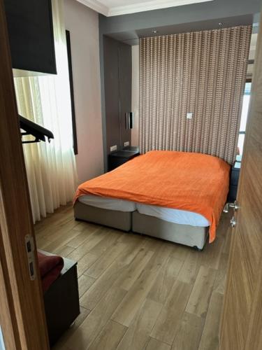 a bedroom with a bed with an orange blanket at PİNK POİNT APART in Didim