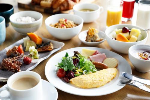 Four Points by Sheraton Nagoya, Chubu International Airport في شوبو: طاولة مع أطباق من الطعام وأكواب من القهوة