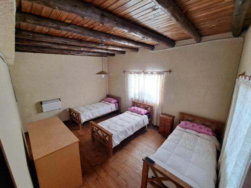 an attic room with two beds and a table at CABAÑAS EL CERRO in Ciudad Lujan de Cuyo