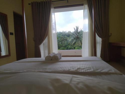 a bedroom with a bed with a large window at Kandy Lotus House in Kandy