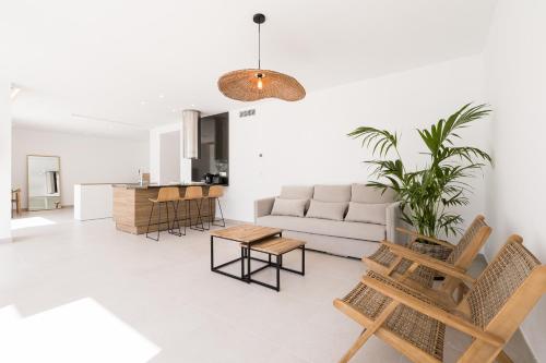 een woonkamer met een bank en een tafel bij Bossa Bay Suites with Private Pool - MC Apartments Ibiza in Ibiza-stad