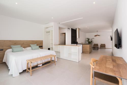 a white bedroom with a bed and a kitchen at Bossa Bay Suites with Private Pool - MC Apartments Ibiza in Ibiza Town