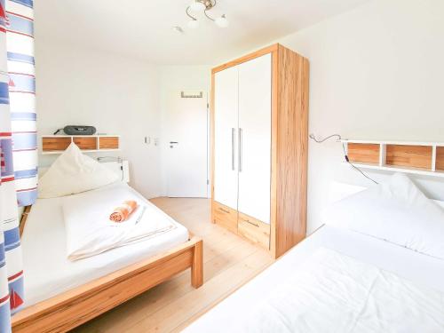ein kleines Zimmer mit 2 Betten und einem Spiegel in der Unterkunft De Möhlenkieker 3 in Greetsiel