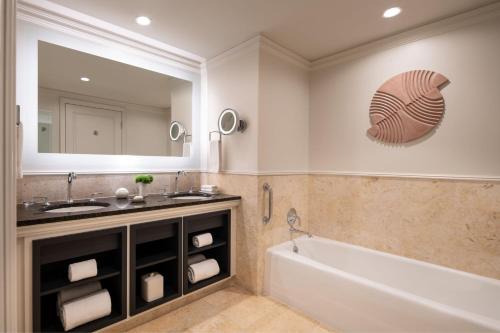a bathroom with a tub and a sink and a mirror at The Ritz-Carlton, Grand Cayman in George Town