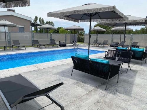 una piscina con sillas y sombrillas junto a una piscina en GERANI apartments, en Órmos