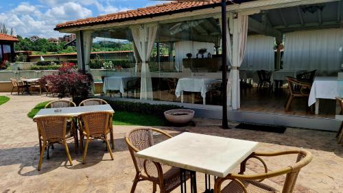 a patio with tables and chairs and a restaurant at Spa Hotel Ezeretz Blagoevgrad in Blagoevgrad
