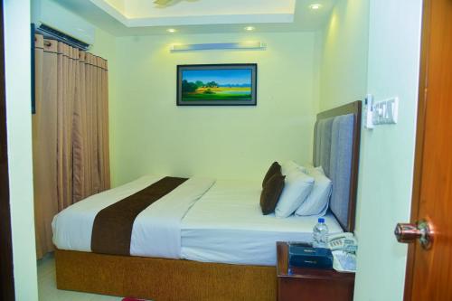 a hotel room with a bed and a picture on the wall at Hotel Crown City in Chittagong