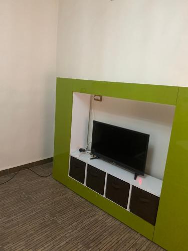 Ajloun 2 bedrooms apartment في عجلون: تلفزيون بشاشة مسطحة جالس على رف في غرفة