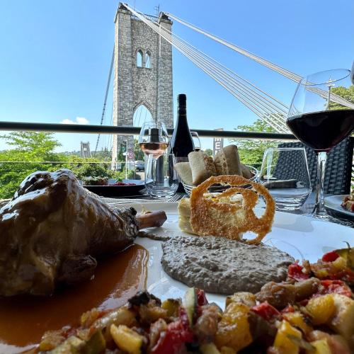 a table with a plate of food and glasses of wine at Logis Hôtel Restaurant Bellevue in Saint-Martin-dʼArdèche