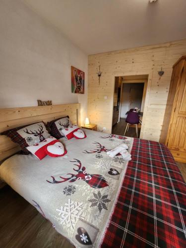 een slaapkamer met een bed met kerstversieringen erop bij Gite Myosotis 2 personnes avec SPA Jacuzzi , jardin, barbecue, dans la Résidence in Ventron
