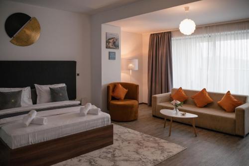 a hotel room with a bed and a couch at Silver Mountain Resort & Spa in Poiana Brasov