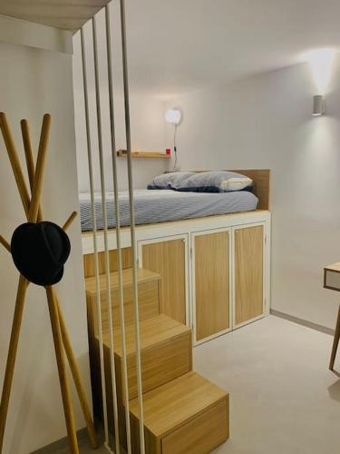um pequeno quarto com uma cama e uma escada de madeira em Miini loft di pregio a Roma Nord- Ponte Milvio em Roma