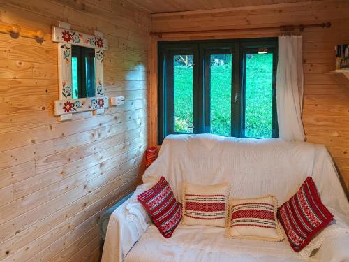 ein weißes Sofa in einem Zimmer mit Fenster in der Unterkunft Almost Heaven - cabană cu vedere în Apuseni in Câmpeni