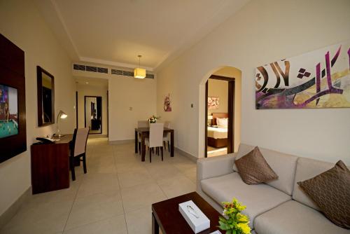 a living room with a couch and a table at Action Hotel Ras Al Khaimah in Ras al Khaimah