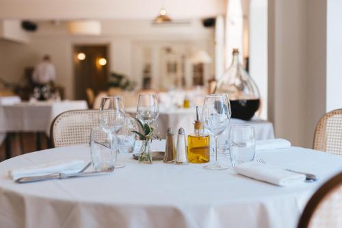 a white table with wine glasses on it at Auberge du Rédier - Logis Hôtels in Colomars