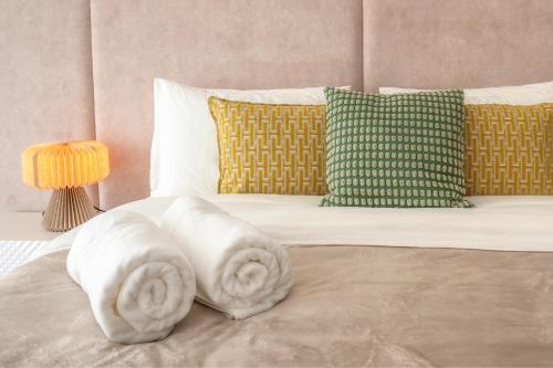 a bed with two pillows on top of it at Belo Horizonte Apart in Parede