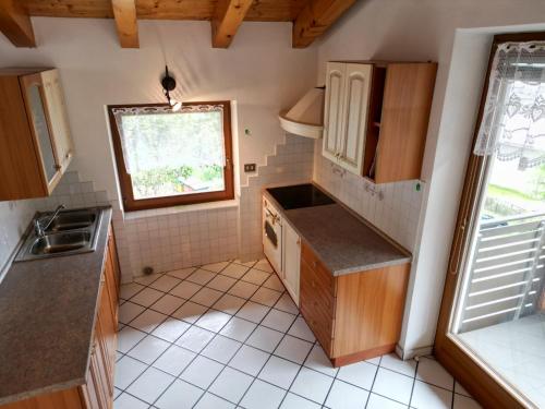 een kleine keuken met houten kasten en een raam bij Chalet Migazzi - mansarda in Cogolo