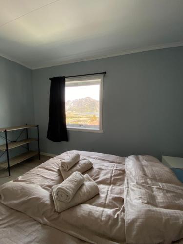 House in the heart of Lofoten with spectacular view في راين: غرفة نوم بسرير كبير عليها مخدات