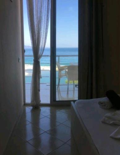 una camera da letto con una porta che conduce alla spiaggia di Diamond Sea a Sarandë