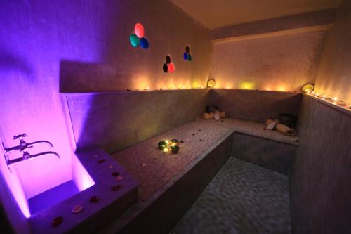 a bathroom with a tub with purple lights on it at Riad De Vinci & SPA in Marrakech