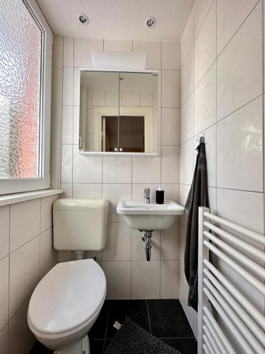 a white bathroom with a toilet and a sink at Caron in Böhl