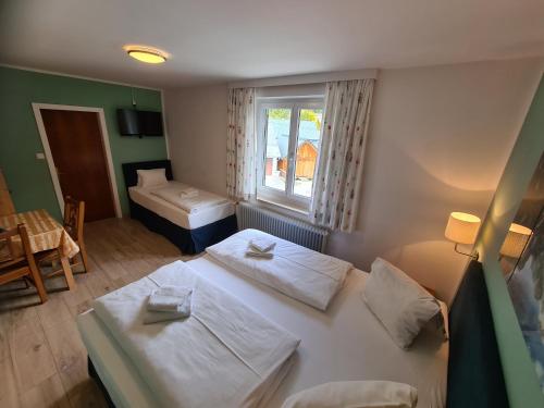ein Hotelzimmer mit 2 Betten und einem Fenster in der Unterkunft B&B Hallstatt Lake - self check in in Obertraun