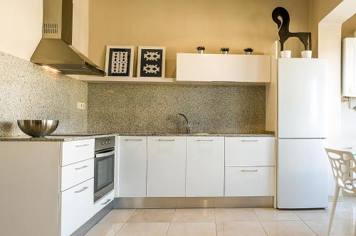 Apartament Turistics Cardona في كاردونا: مطبخ فيه دواليب بيضاء وثلاجة بيضاء