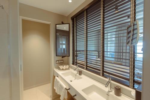 a bathroom with two sinks and a large window at Strandhotel Ostende in Ahlbeck
