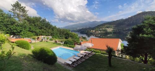 a house with a swimming pool and a view of a river at Bella Casa in Vieira do Minho