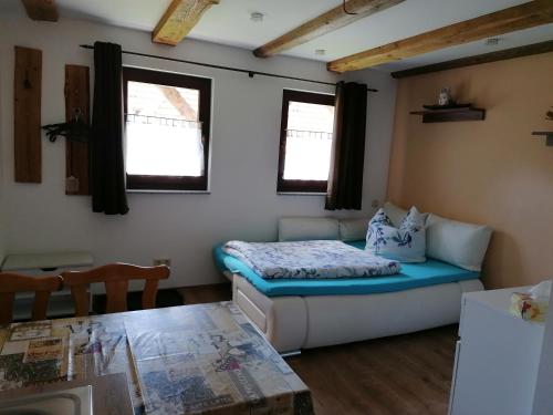 Cette petite chambre comprend un lit et une table. dans l'établissement Ferienwohnung Max, à Schirgiswalde