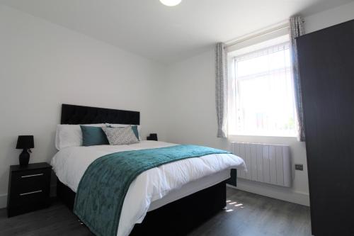 a white bedroom with a large bed and a window at F6 Hammonds Row in Preston
