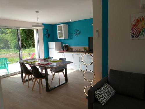 un salon avec une table et des chaises et une cuisine dans l'établissement Domaine des Hameaux du Lac - BG, à Saint-Pardoux
