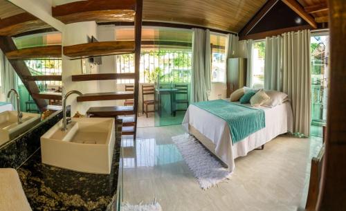 a bedroom with a bed and a tub and a sink at Flat Morro e Casa Blanca in Morro de São Paulo