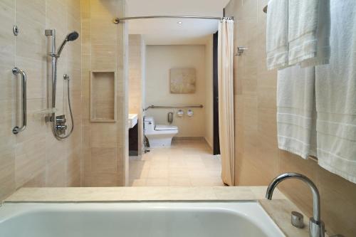 a bathroom with a bath tub and a toilet at Sheraton Nha Trang Hotel & Spa in Nha Trang