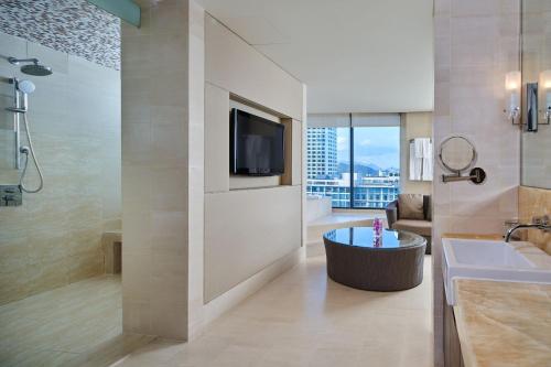 a bathroom with a tub and a sink and a tv at Sheraton Nha Trang Hotel & Spa in Nha Trang